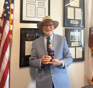 Senator Laird receives a bobblehead from the California Arts Council