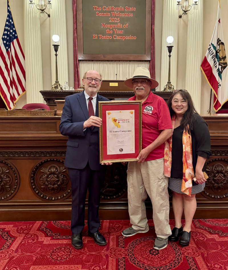 Senator Laird with staff from El Teatro Campesino on the Senate Floor holding a resolution in honor of Nonprofit of the Year.