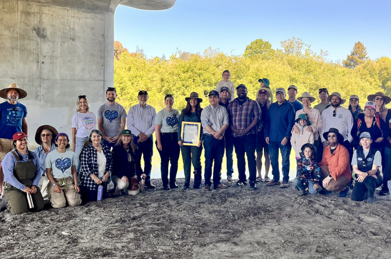 Senator Laird with a group of volunteers taking a photo alongside the San Lorenzo river for Pitch In All County Clean Up Day.