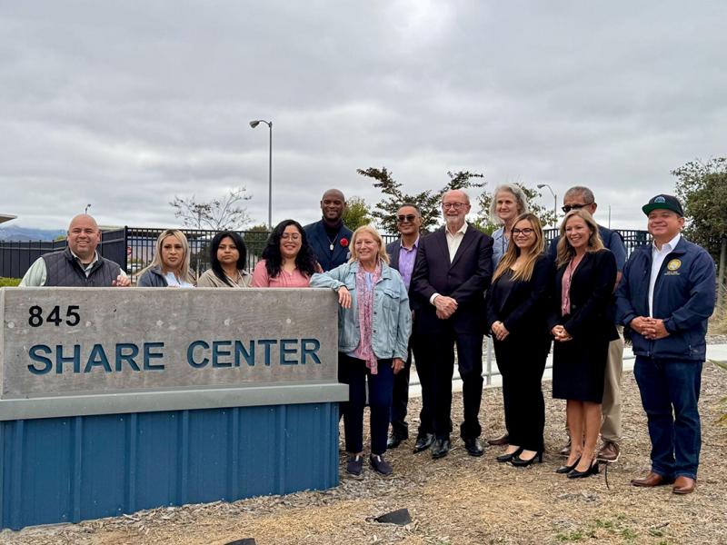Sen. Laird standing alongside local electeds, nonprofit leaders, and others at the SHARE Center entrance sign in Salinas