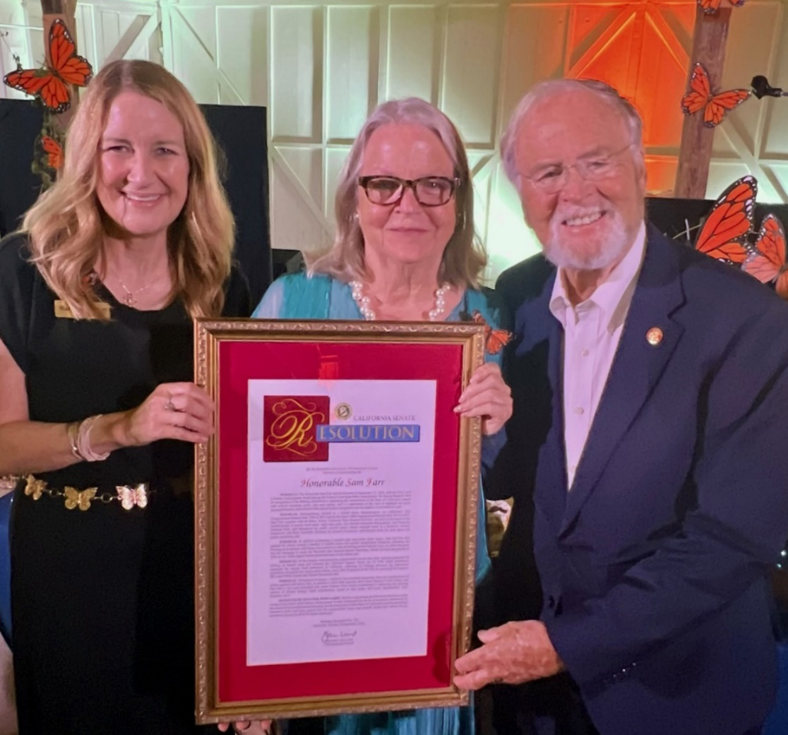 Kara Woodruff presents former Congressman Sam Farr with a Senate resolution.